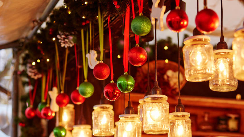 Weihnachtsstand mit hängenden Kerzen und Weihnachtsbaumkugeln