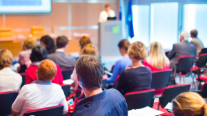 Eine Gruppe Menschen von hinten während eines Vortrags