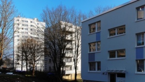Hinten Hochhaus 12 Etagen, Mitte Wohnhaus 6 Etagen mit Balkonen und Flachdach, vorne Wohnhaus 3 Etagen mit Flachdach. 