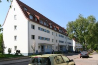 Altbauten mit Spitzdach, 4 Etagen, Vorgärten begrünt. Fassade weiß mit blauen Akzenten. Straße. Altbauten mit Spitzdach, 4 Etagen, Vorgärten begrünt. Fassade weiß mit blauen Akzenten. Straße.