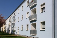 Detail hellblaue Fassade mit Loggien. Balkonbrüstung mit Lochblech verkleidet.