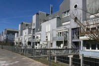 Wohnblock mittelblau mit Blechverkleidung in oberen Etagen, 3 und 4 Etagen, Balkone, Metallstege führen zu Eingängen.