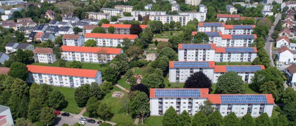 sanierte Wohnhäuser in weiß mit drei und vier Etagen. Gebäude rechts mit Solarpanels auf den Dächern. sanierte Wohnhäuser in weiß mit drei und vier Etagen. Gebäude rechts mit Solarpanels auf den Dächern.