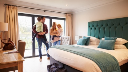 Familie in Hotelzimmer Familie in Hotelzimmer Shutterstock_411218071_Monkey Business Images