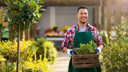 Gärtner Mann trägt Pflanzen