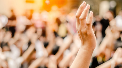 Symbolbild Bürgerbeteiligung mit erhobener Hand in der Menge