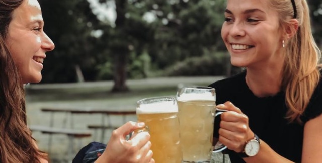 Zwei Frauen stoßen mit Bier an
