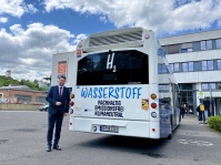 Eine Person steht neben einem Bus. 