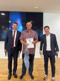 Links der OB, in der Mitte ein Mann mit Urkunde, rechts der Amtsleiter