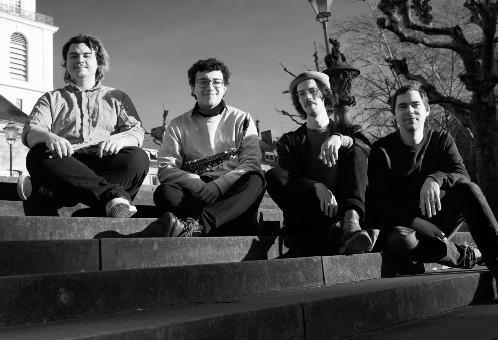 What is Jazz Vier Männer sitzen im Freien auf einer Treppe.