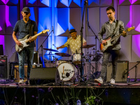 Eine Band steht auf einer bunt angestrahlten Bühne