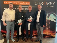 Vier Männer stehen vor einer Fotowand