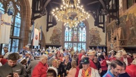 Bunt verkleidete Menschen feiern in historischem Saal